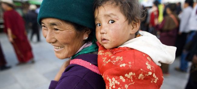 © UNICEF/Palani Mohan A woman carries a child in Barkhor, in the Tibet Autonomous Region. (file)
