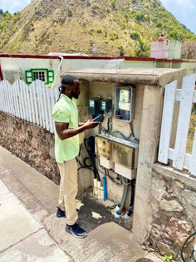 A Saba Electric Company (SEC) employee reading the meters.