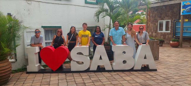 Journalists with “I Love Saba” sign.