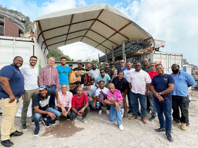 The construction workers of the Under the Hill project with government officials, including Island Governor Jonathan Johnson (standing, third from left) and Commissioner Rolando Wilson (standing, fifth from right), Maarten Koster of Bazalt Wonen (standing, seventh from right) and Zoubeir el Atmani of Van Boekel (second from left).