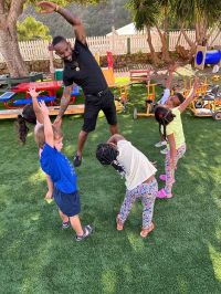 Allan Carolina does exercises with a group of daycare children.