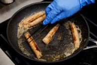 The sausages are fried in margarine. Photo: Robin van Lonkhuijzen ANP